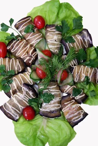 Eggplants filled by cheese and garlic on leaves of salad