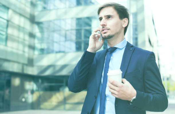 istock Businessman talking on the phone with coffee 691822016