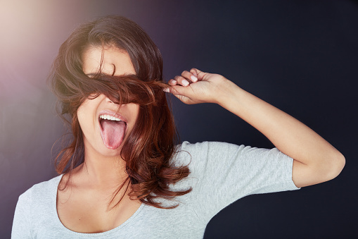 Cropped shot of a beautiful young woman posing with her hair over her eyes in the studio