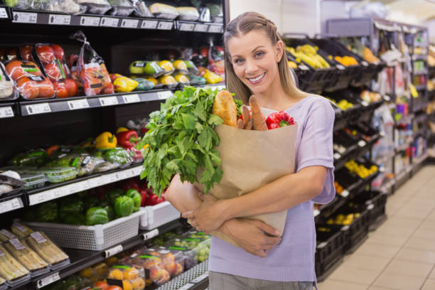 istock Pretty blonde holding bag with bread and vegetable 691828998