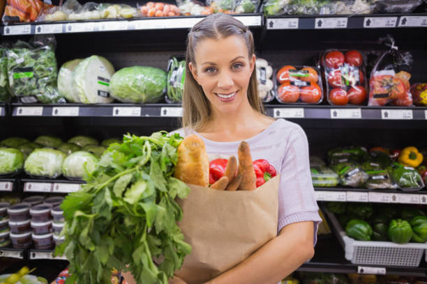 istock Pretty blonde holding bag with bread and vegetable 691829022