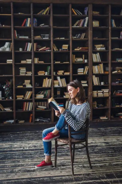 Photo of Young woman reading in the library