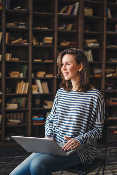 istock Young woman studying in the library 691832316