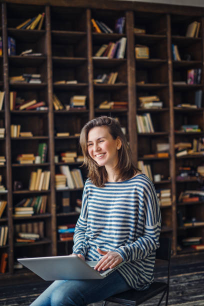 istock Young woman studying in the library 691832408