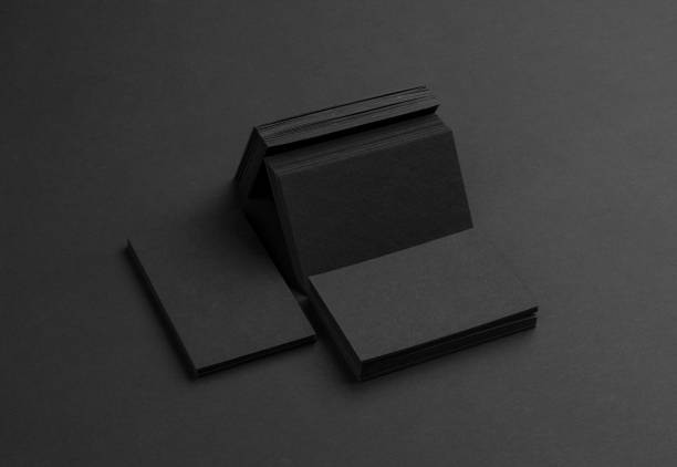 istock Black business cards isolated on black background 691832564