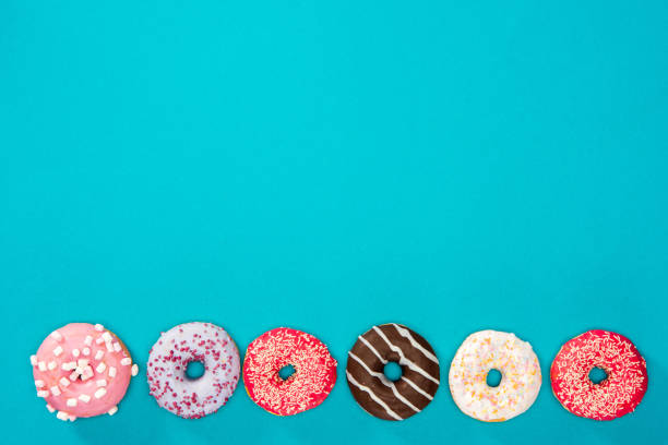 istock Row of sweet donuts isolated on blue background 691833652
