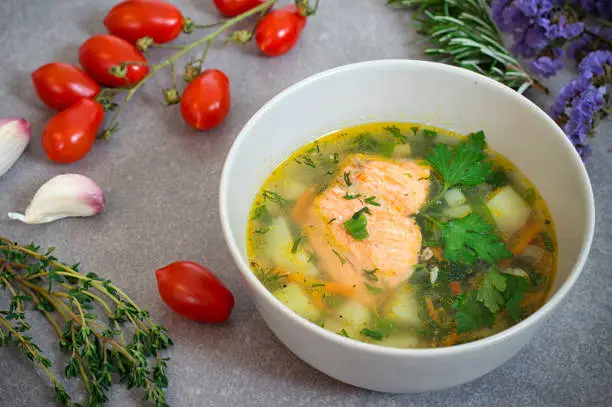 Soup with salmon. Gray stone background. Close-up. Top view