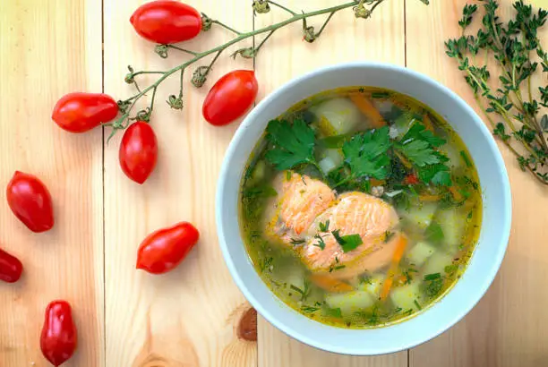 Soup with salmon. Wooden background. Close-up. Top view