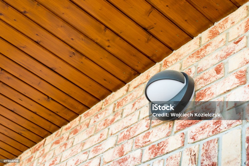 Modern wall lamp with motion and light sensor on the brick wall Modern wall lamp with motion and light sensor on the brick wall - pathway or wall light for modern design building or house - motion activated porch light - part of home security system Sensor Stock Photo