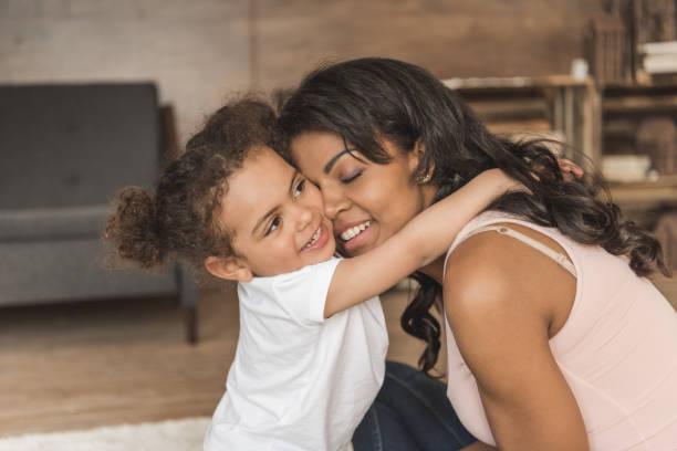 istock little daughter hugging smiling mother while spending time at home 691856348