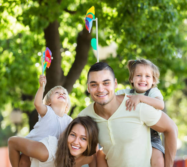 istock Happy family playing colorful windmills 691857352