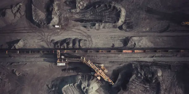 Coal mining. Aerial view. Excavator loading train cargos