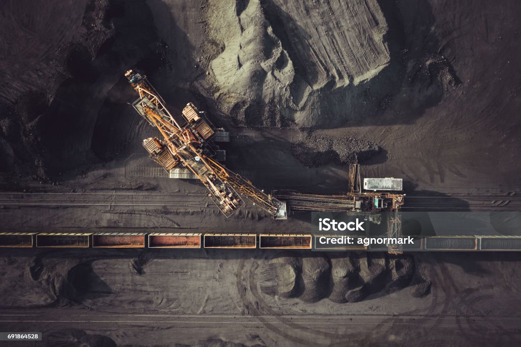 Coal mining from above Coal mining. Aerial view. Excavator loading train cargos Mining - Natural Resources Stock Photo