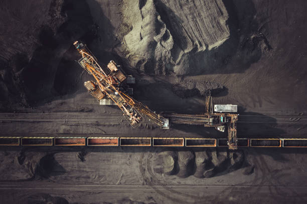 Coal mining from above Coal mining. Aerial view. Excavator loading train cargos fossil photos stock pictures, royalty-free photos & images