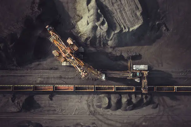 Coal mining. Aerial view. Excavator loading train cargos