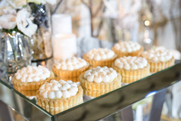 istock Cupcakes with white cream on the table decorated with white flowers and candles 691870724