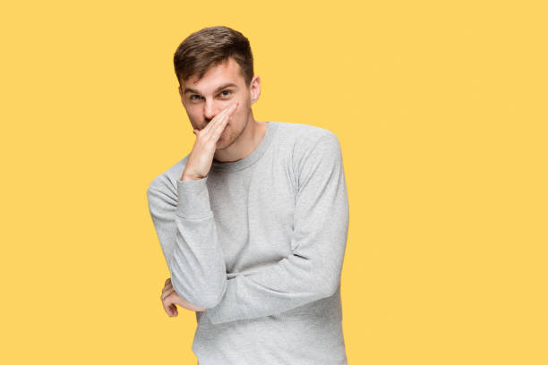 istock The young serious man looking cautiously and Speaking secret 691871638
