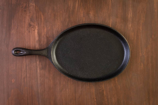 Empty fajita cast iron skillet on a wood background.