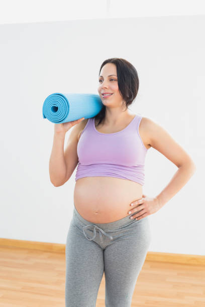 istock Happy pregnant woman holding exercise mat 691879188