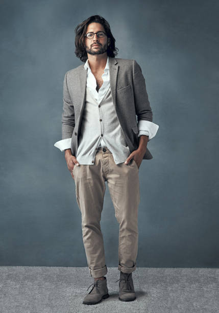 Full length studio portrait of a handsome and stylish young man against a grey background