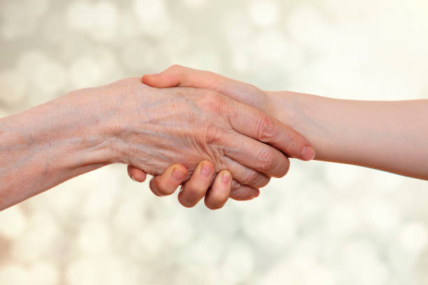 istock Handshake between an old person with a wrinkled hand and a kid 691888878