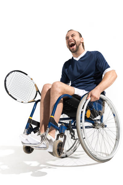 tenista joven discapacitado sentado en silla de ruedas y riendo aislado en blanco - wheelchair tennis physical impairment athlete fotografías e imágenes de stock