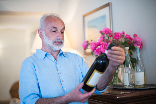 Family holidays in Langhe region, Piedmont, Italy: Man choosing and tasting wine