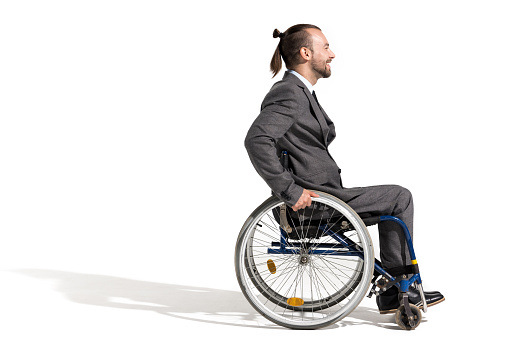 side view of smiling disabled businessman in wheelchair isolated on white
