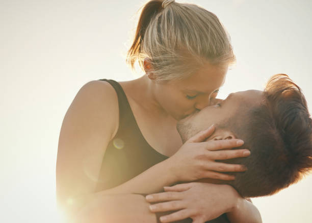 Kissing is a great calorie burner Shot of a young couple kissing outdoors kissing on the mouth stock pictures, royalty-free photos & images