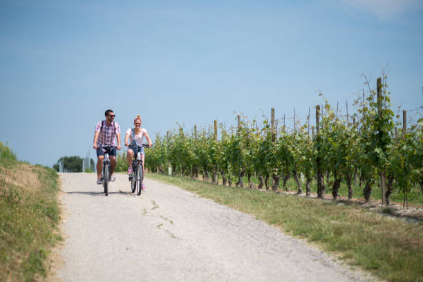 Family holidays in Langhe region, Piedmont, Italy: Electric bikes trip in the hills Family holidays in Langhe region, Piedmont, Italy: Electric bikes trip in the hills agritourism stock pictures, royalty-free photos & images