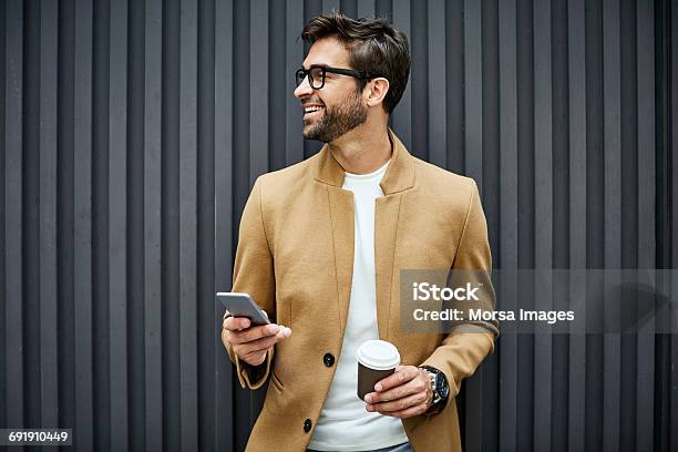 Smiling Businessman With Smart Phone And Cup Stock Photo - Download Image Now - Men, Businessman, Elegance