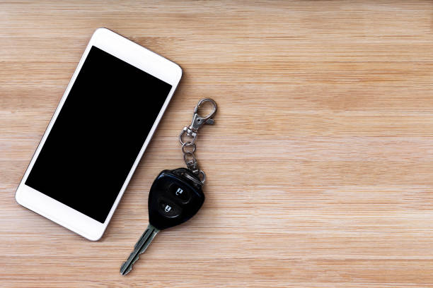 mobile phone and key on wood texture background.
