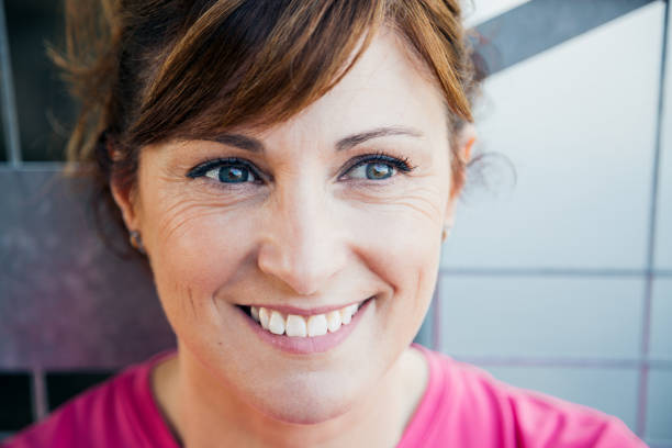 Cute dreamy middle aged woman face leaning on a fence