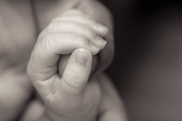 istock baby hands holding dads finger 691930926