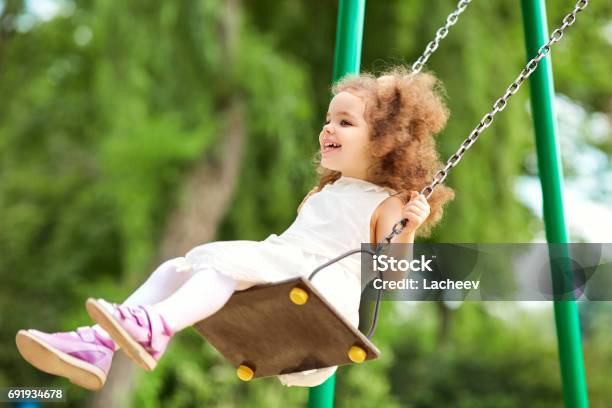 Foto de Criança Balançando Em Um Balanço No Parque No Parque e mais fotos de stock de 2-3 Anos