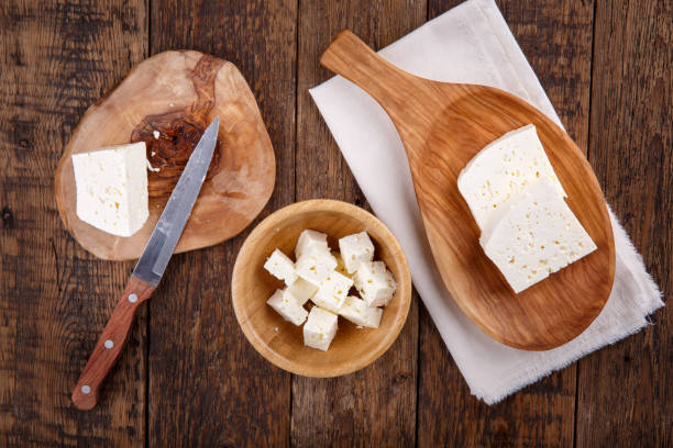 tranches de fromage saumurée blanc de lait de vache sur la table en bois. vue de dessus. - fetta cheese photos et images de collection