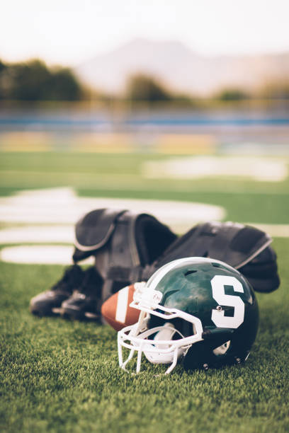 競技場で緑のアメリカン フットボールのヘルメット - football helmet american football green american football uniform ストックフォトと画像