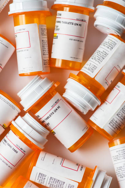 istock A bunch of prescription pill bottles grouped on a table with white background 691949458