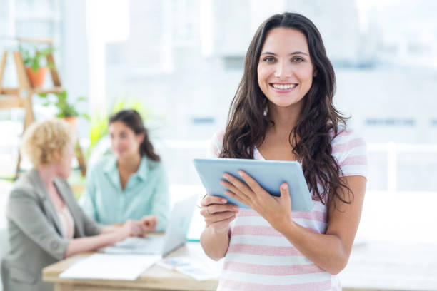 istock Smiling businesswoman using a tablet with colleagues 691966202