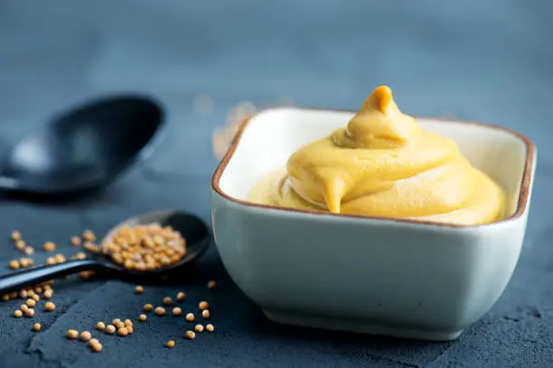 mustard in bowl and on a table