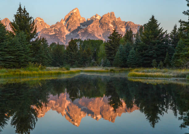 istock Reflections of sunrise over Grand Tetons 691975438