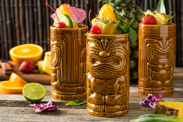 Refreshing Cold Tiki Drink Cocktails Refreshing Cold Tiki Drink Cocktails with Pineapple Cherry Orange Garnishes tiki stock pictures, royalty-free photos & images