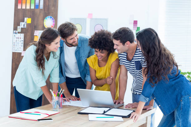 istock Group of young colleagues using laptop 691984910