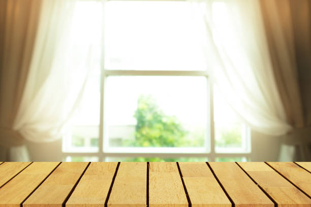 istock Perspective wooden table on top over blur window background, can be used mock up for montage products display or design layout. 691992158