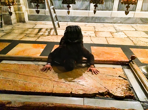 Jerusalem, Israel - 29 Feb, 2016: Man pray on The oldest Christian sanctuary - Stone of Unction