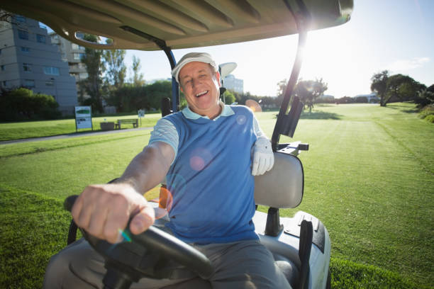 istock Golfer driving his golf buggy and smiling at camera 692003690