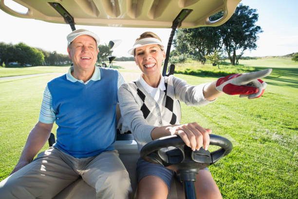 istock Happy golfing couple sitting in golf buggy 692008584