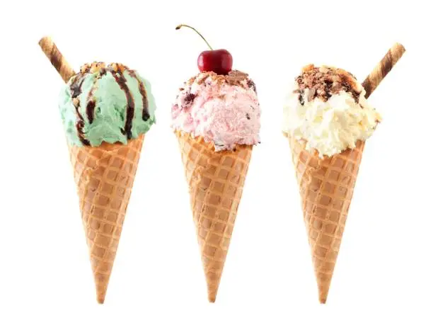 Photo of Pistachio, cherry and vanilla ice cream in waffle cones isolated on white