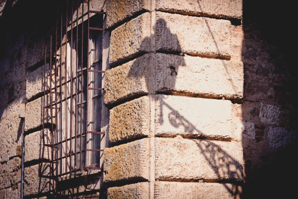 The shadow of an italian street lamp on the facade of a building