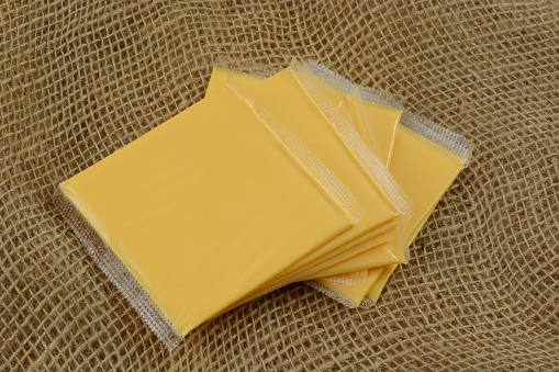 Individually wrapped cheese slices on burlap
